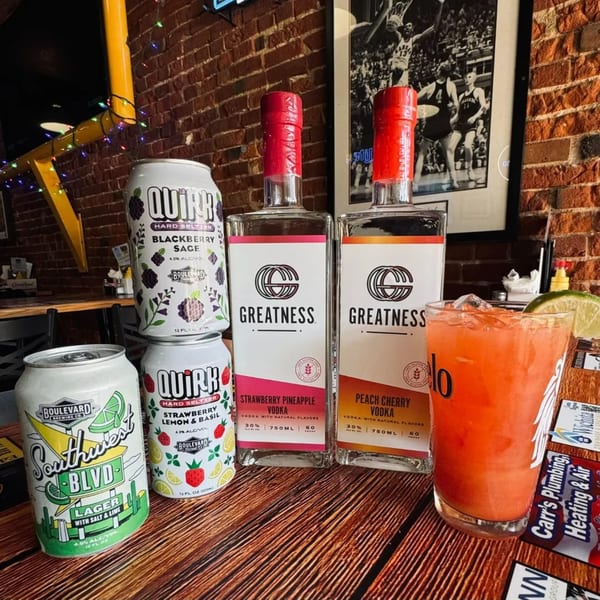 Assortment of Emerson Biggins beverages, including Quirk seltzers, Boulevard lager, Greatness vodkas, and a cocktail.