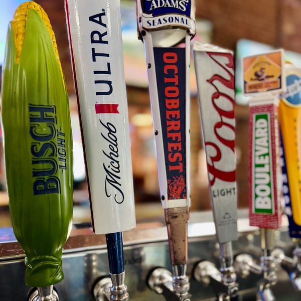 Close-up of several beer taps at Emerson Biggins, including Busch Light, Michelob Ultra, and Oktoberfest.